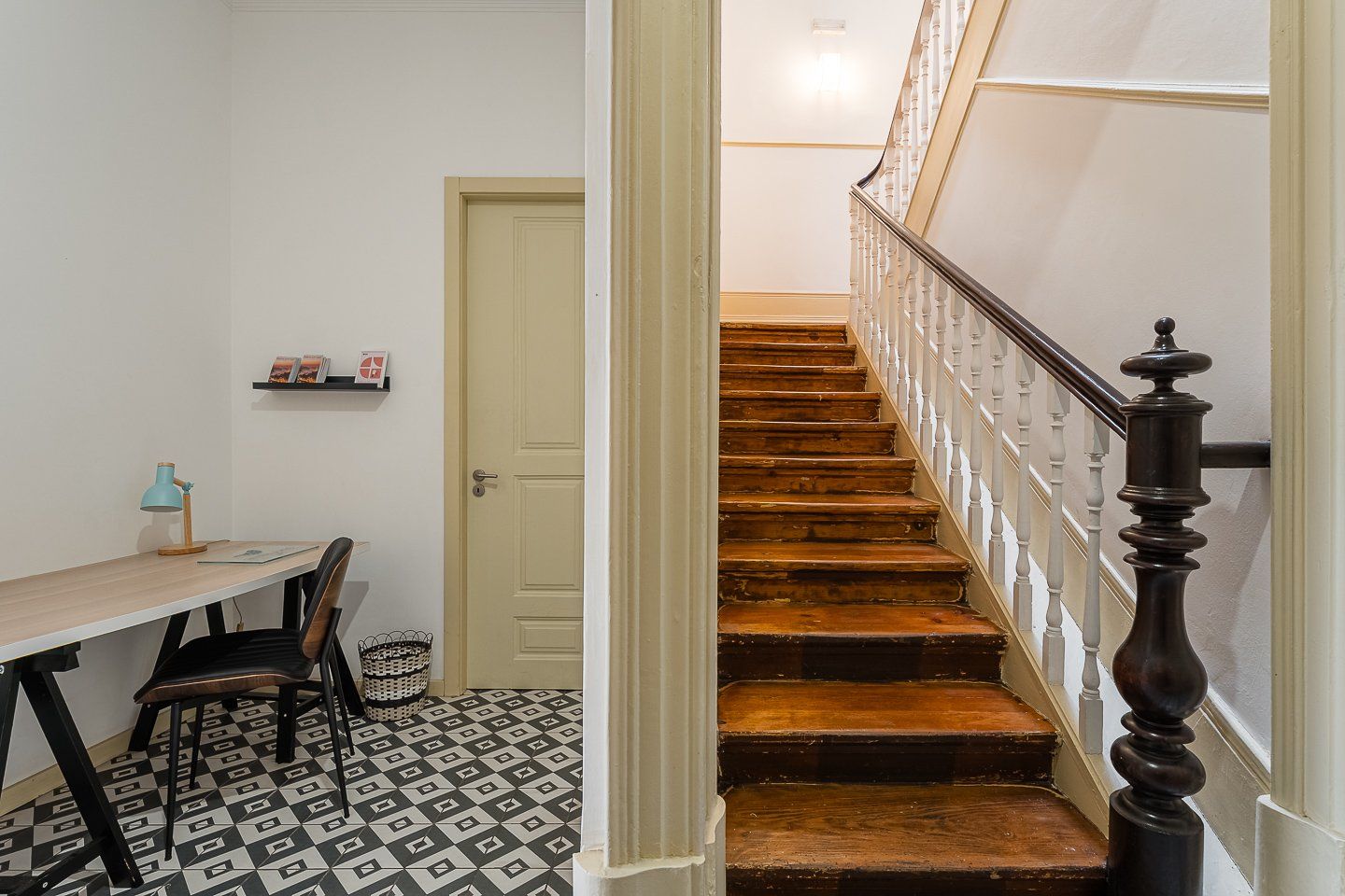Una escalera de madera con balaustres blancos que lleva a un piso superior.