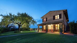 A two-story house with a patio area, a large tree, and a well-maintained lawn. - Podere Gellino 14, Emma Villas (Chianciano Terme)
