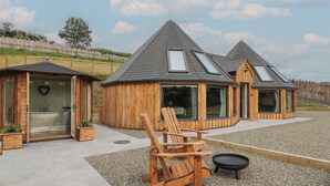 Une cabane en bois équipée d’un sauna, d’un jacuzzi et d’un espace barbecue.