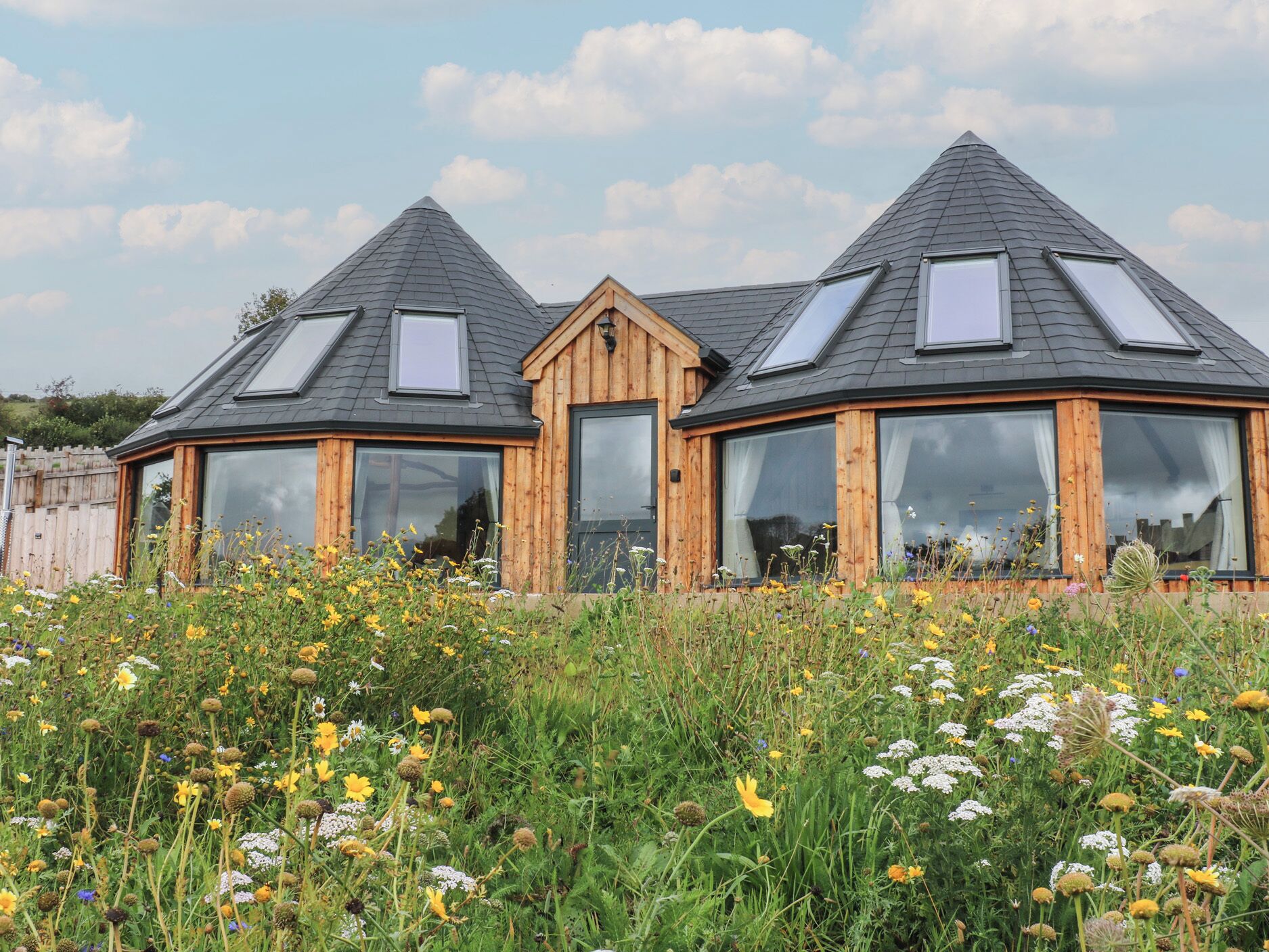 Una casa moderna con fachada de madera y amplias ventanas.