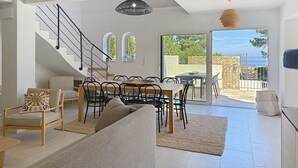 Un vaste espace de vie comprenant un escalier, une table à manger et un canapé.