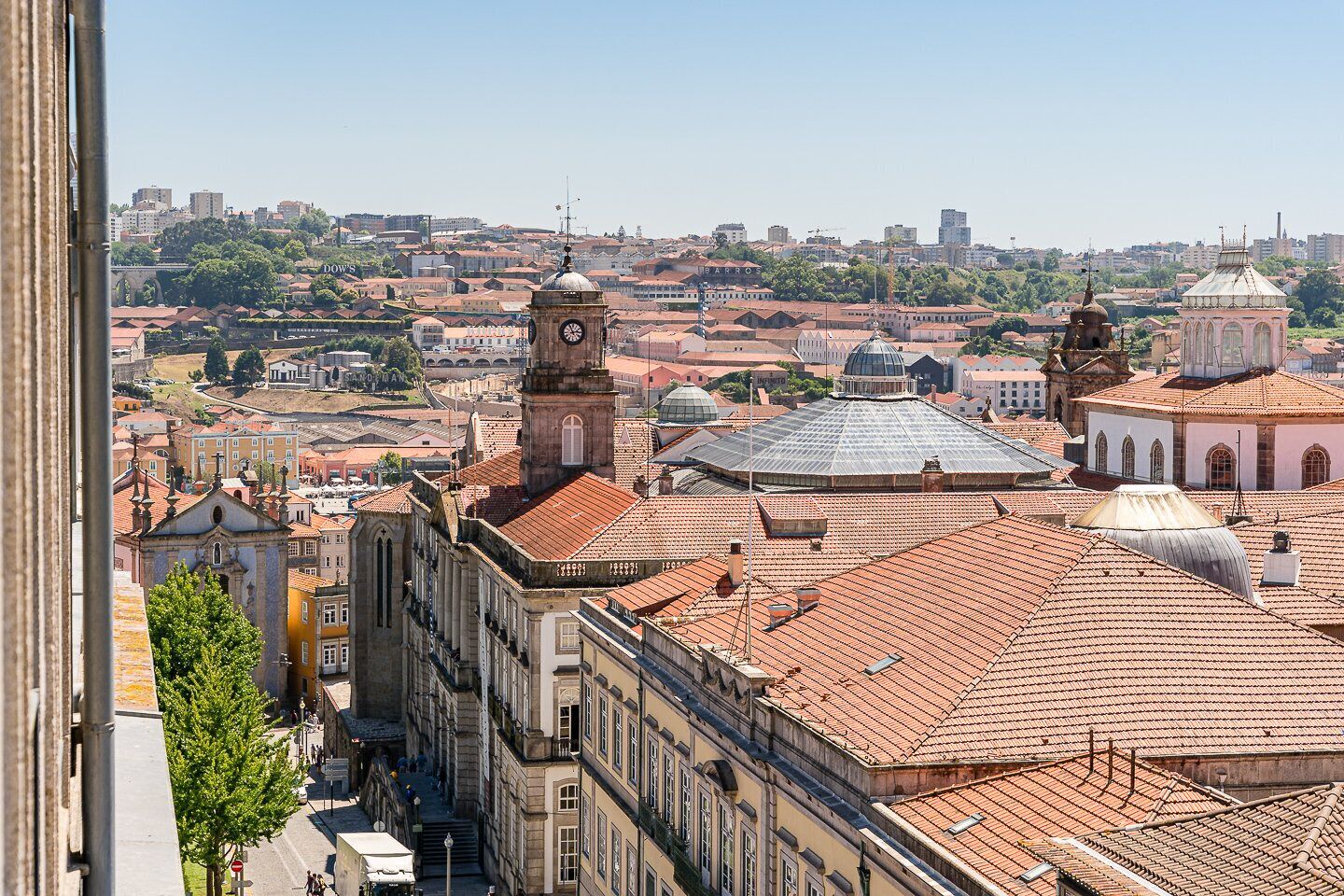 Un paisaje urbano histórico con edificios destacados, incluyendo una torre de reloj y estructuras con cúpulas.