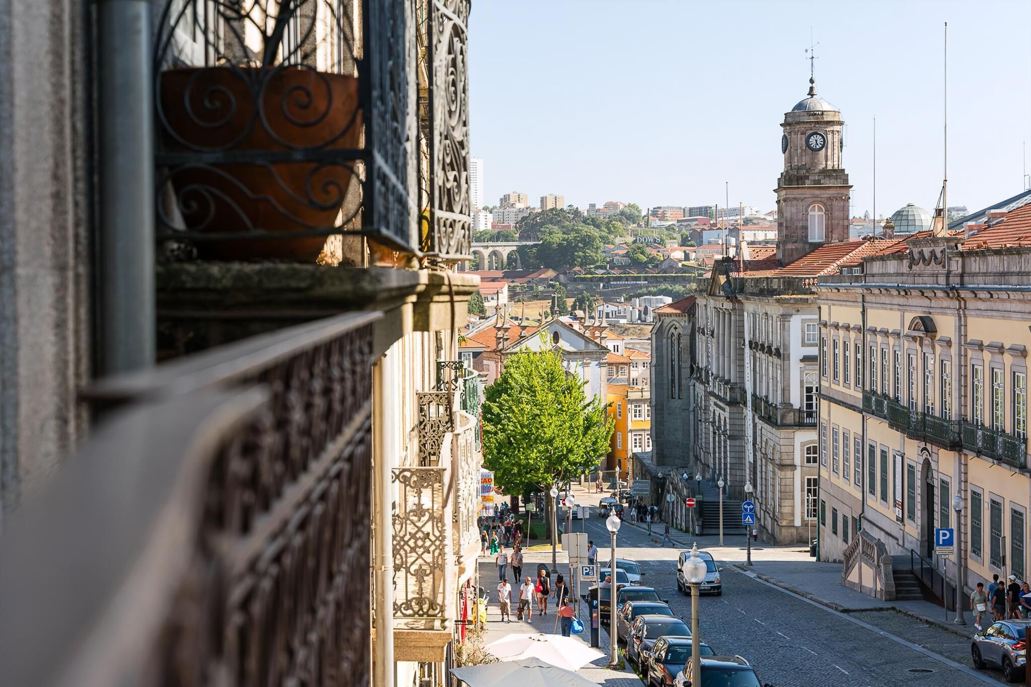 A street view with historic buildings, a clock tower, and a clear sky.