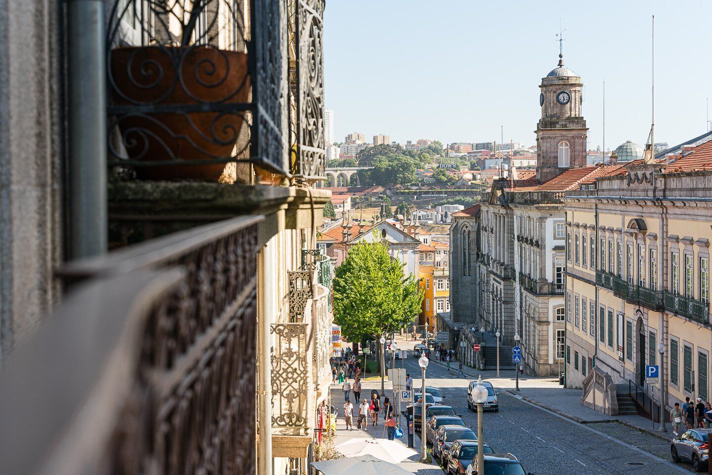 Une vue de rue avec des bâtiments historiques, une tour de l’horloge et un pont en arrière-plan.