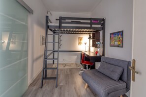 A bunk bed with a desk and chair, a sofa, and a door with a handle. - Spacious Central Apartment with Wi-Fi and Portable Air Conditioning (Lecce)