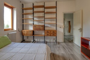 A bedroom with a bed, a window, a radiator, a wardrobe, and a door leading to another room. - Spacious Central Apartment with Wi-Fi and Portable Air Conditioning (Lecce)