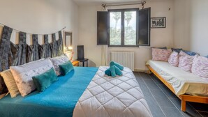 A bedroom with a bed, a sofa, a window with curtains, a radiator, and a picture on the wall. - Holiday Home 'Masseria Il Fondone Up' with Shared Pool, Wi-Fi and Air Conditioning (lizzanello)
