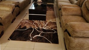 Een woonkamer met twee leren banken, een zwarte salontafel en een open haard.