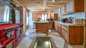A kitchen with wooden cabinets, a red stove, and a microwave. - Guest Room 3 - Aurélie's Farm (Montvalezan)