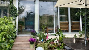 Ein Haus mit Terrasse, Essbereich und Garten.