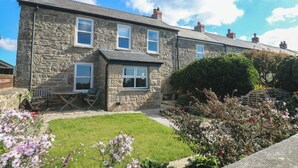 A stone house with a small front porch and a well-maintained garden. - Sea Holly (Penzance)
