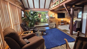 A cozy living room with leather sofas, a blue rug, and wooden beams. - Charming rustic, family friendly farmhouse
near Detroit Lakes - 4 beds available (Rochert)