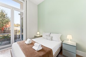 A hotel room with a bed, two bedside tables, a window, and a view of the outside. - Guestready - Porto Home Guesthouse (Porto)