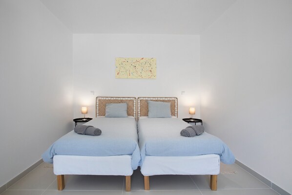 A room with two beds, each with a headboard, bedside tables, and lamps. - Villa 'Peace House Lourinhã 8' with Mountain View, Private Pool and Wi-Fi (Lourinhã)