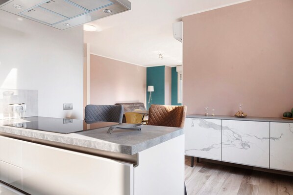 Une cuisine moderne dotée d’un plan de travail en marbre, d’un four encastré et d’une armoire blanche agrémentée de détails en marbre.