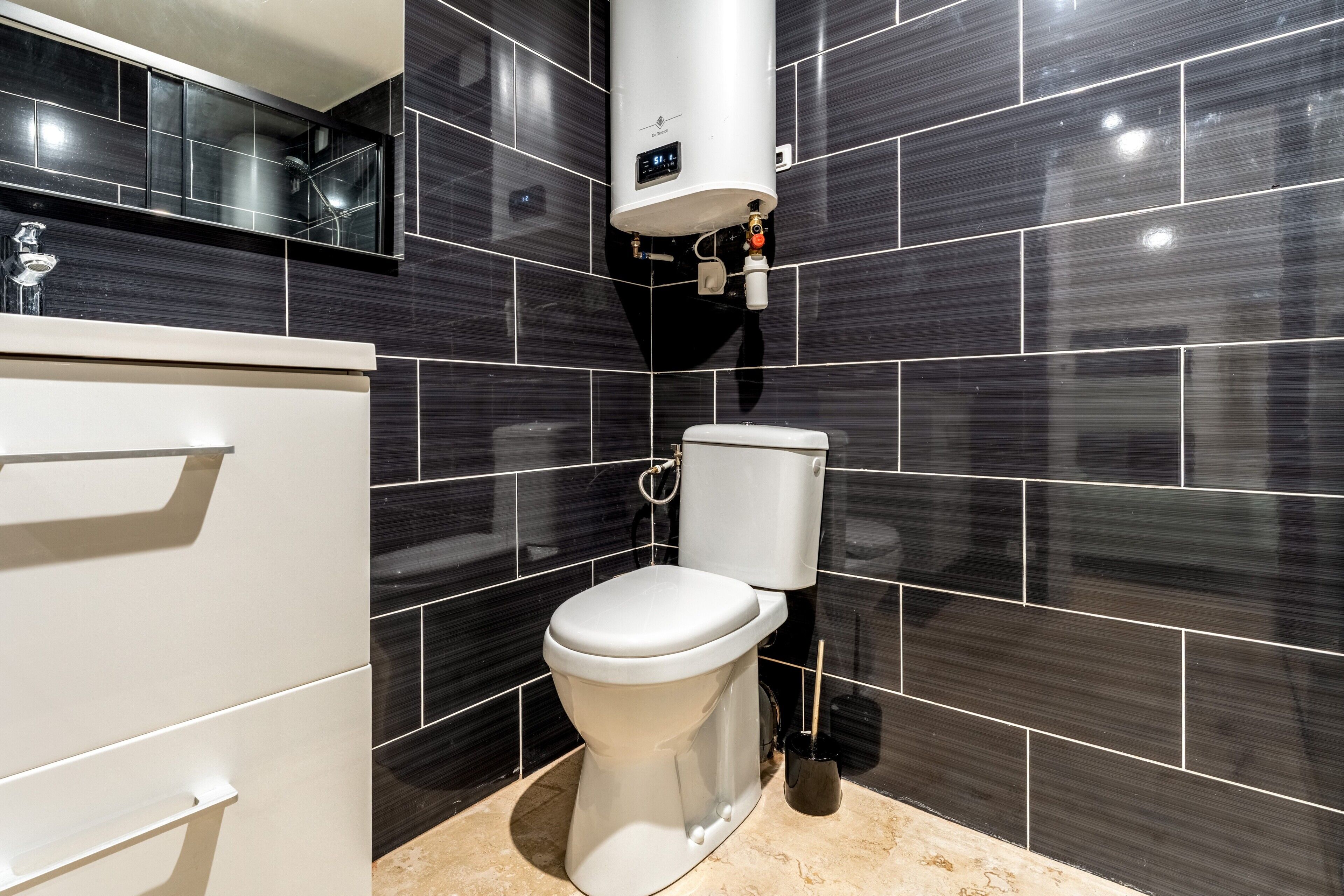A modern bathroom with a toilet, a sink, and a shower.