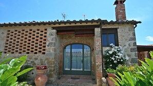 A stone building with a tiled roof, a brick chimney, and a green door. - Casalecchi - Cottage between Siena & Florence (Staggia)