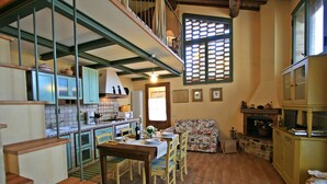A cozy kitchen with a dining area, wooden staircase, and a fireplace. - Casalecchi - Cottage between Siena & Florence (Staggia)