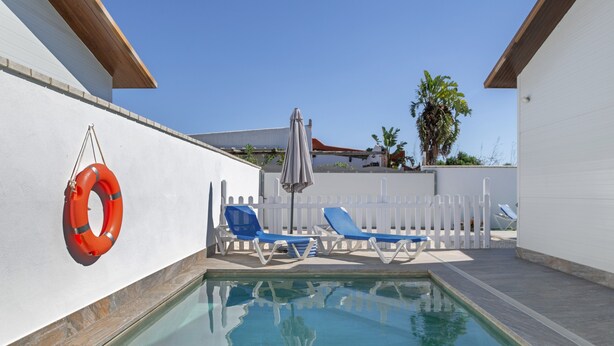 A swimming pool with lounge chairs and a life preserver. - Holiday Home 'Casa Verde Agua' with Private Pool, Wi-Fi and Air Conditioning (Conil de la frontera)