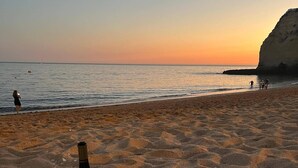 A beach scene with a pizza box, a bottle of wine, and glasses on the sand. - 'Beira Mar' Carvoeiro - Modern, intimate studio -Distant Ocean View - Fast Wifi (Carvoeiro)