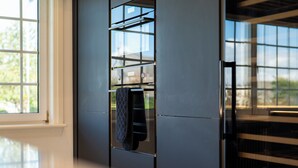 Una cocina moderna con horno integrado y ventana con vista a follaje.