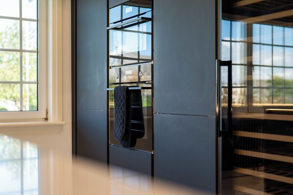 A modern kitchen with a built-in oven and a window with a view of greenery. - No.22 Shalloch House  (Ayr)