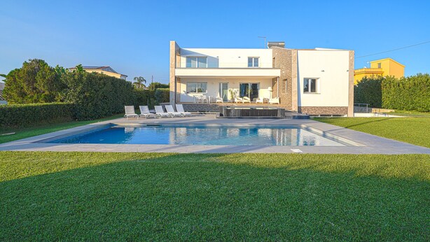 A modern two-story house with a swimming pool, a patio with lounge chairs, and a well-maintained lawn. - Villa Opulentia with Pool and Sea View (Siracusa)