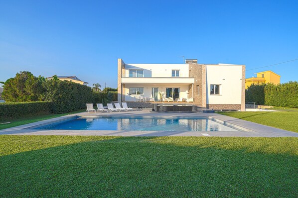 A modern two-story house with a swimming pool, a patio with lounge chairs, and a well-maintained lawn. - Villa Opulentia with Pool and Sea View (Siracusa)
