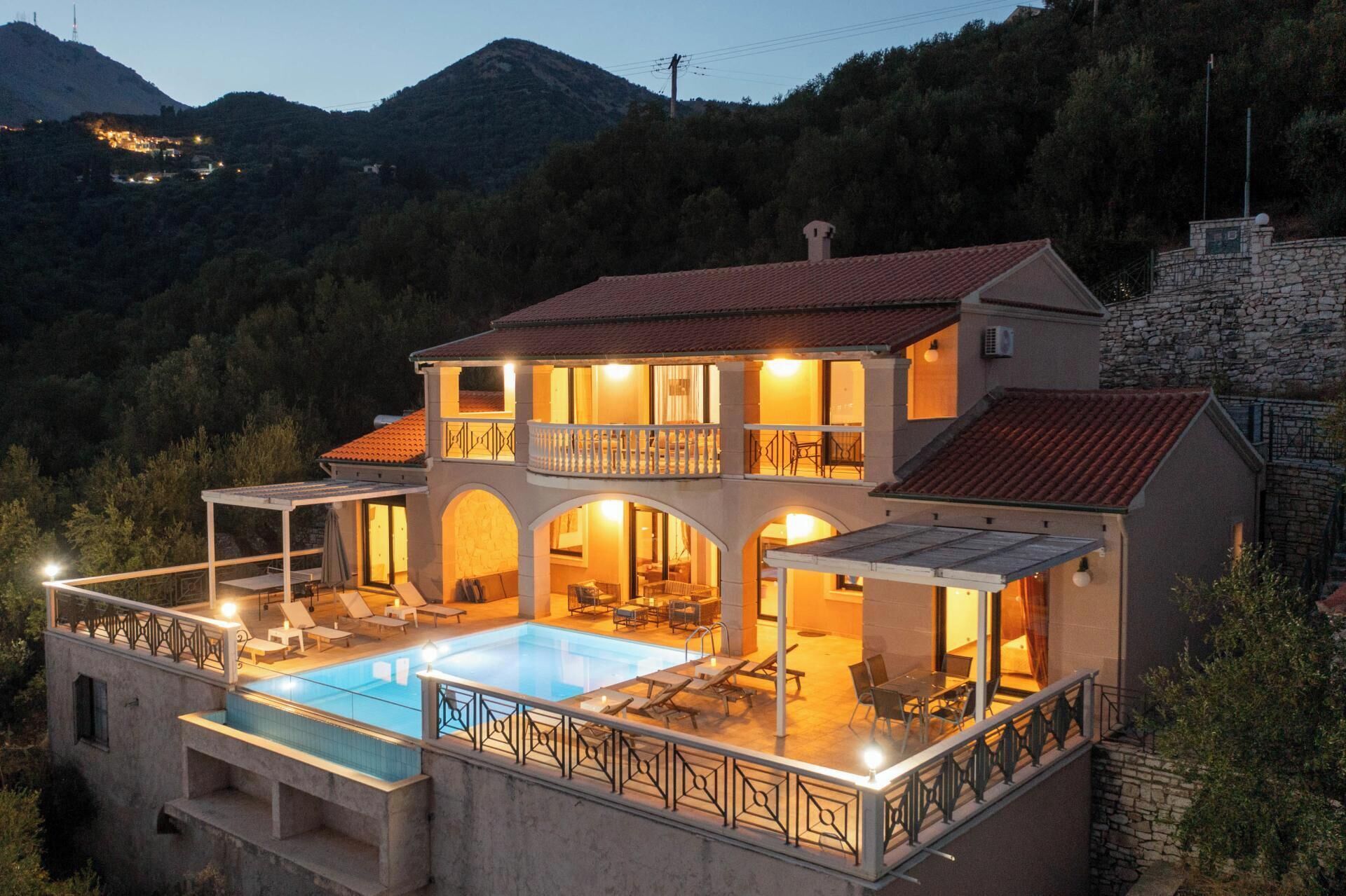 Ein zweistöckiges Haus mit Swimmingpool, Außenbereich und einer Steinmauer.