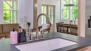 A modern kitchen with a large sink, wooden beams, and large windows. - Dolly's Den at Selah- 3 bed 2 bath Sleeps 7 (Norman)