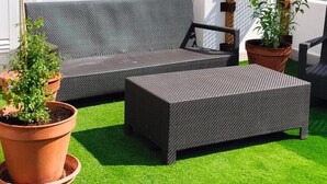 A rooftop patio with outdoor furniture, a white wall, and a wooden fence. - MAREVITA HOSTEL (Alicante)
