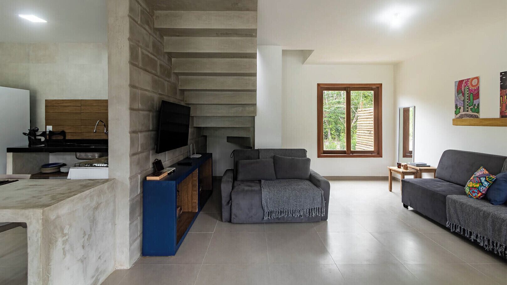 Un salón amplio con sofá, televisión y un mueble de madera.