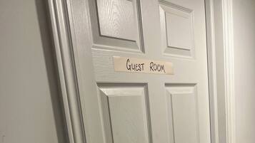 A white door with a sign reading 'Guest Room' and a doorbell.