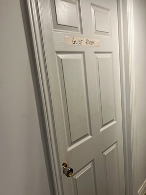 A white door with a sign reading 'Guest Room' and a doorbell.