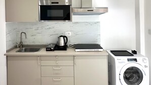 A modern kitchen with a microwave, oven, and a built-in washing machine. - Callas Luxury Apartment (Roma)