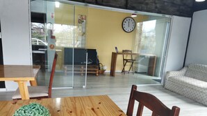 Una sala de estar moderna con una mesa de madera, un sofá y un separador de vidrio.