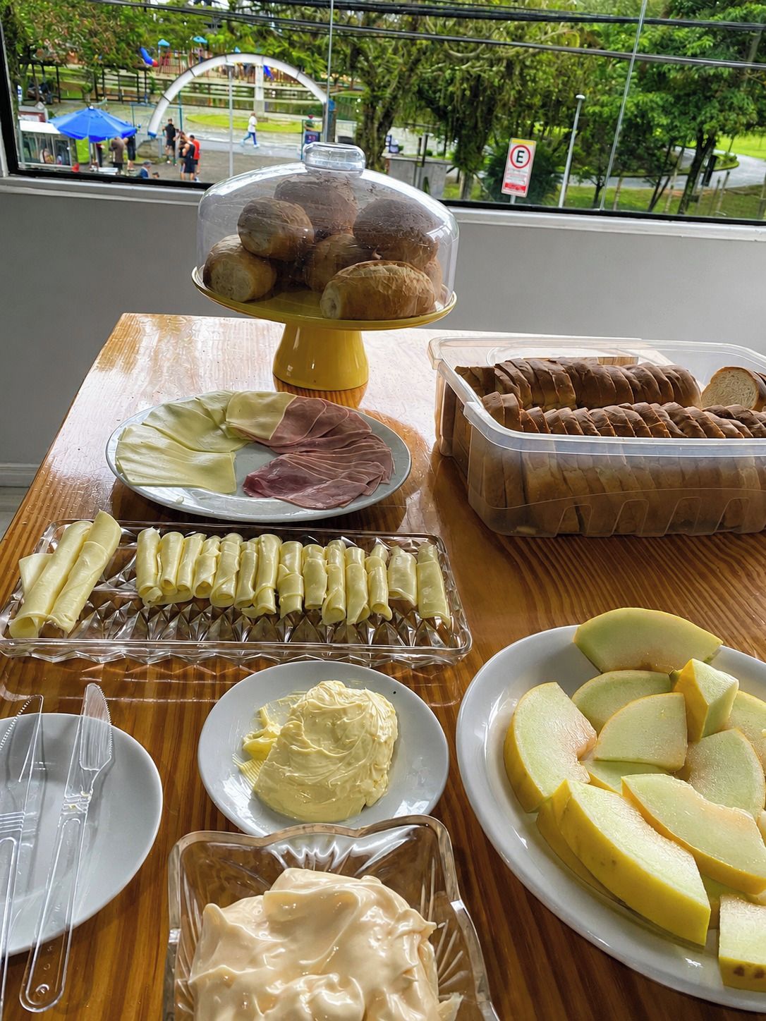 Una mesa de buffet con diversos alimentos, como pan, queso y fruta.
