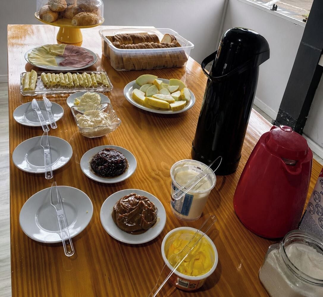 Een ontbijtbuffet met diverse gerechten en bestek op een houten tafel.