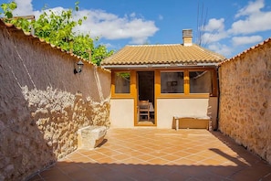 A small building with a tiled patio, a door, and a window.