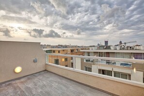 Eine Dachterrasse mit Blick auf eine Stadtlandschaft, einschließlich Gebäude und Baukränen.