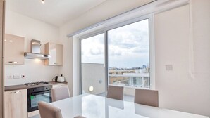 Une cuisine moderne équipée d’une cuisinière à gaz, d’un four et d’un coin repas avec une grande table et des chaises.