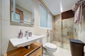 A modern bathroom with a white sink, a toilet, and a glass shower enclosure. - Oakville +, Private Pool & BBQ & Games Room (Xagħra)