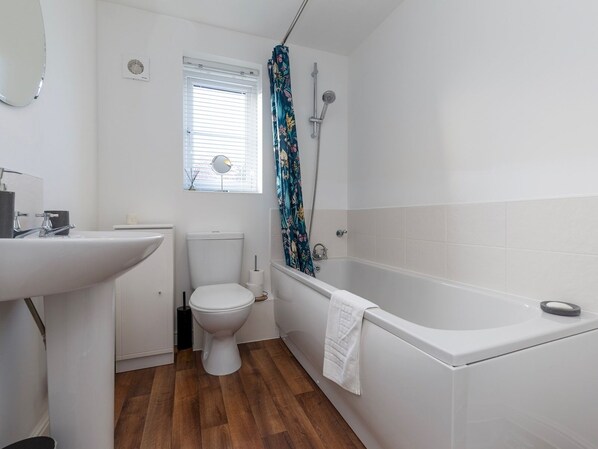 Een badkamer met toilet, wastafel en bad.