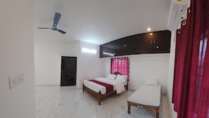 Un dormitorio con una cama, una cama individual, un ventilador de techo y una ventana con cortinas.