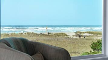 A view from a window overlooking a beach with people and a lifeguard tower.