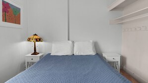 A bedroom with a bed, two nightstands, a lamp, and a wall-mounted shelf. - The Tides by the Sea - Entire rental unit in Seaside, Oregon, United States (Seaside)