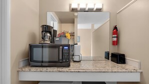 Eine Küche mit Mikrowelle, Kaffeemaschine und Feuerlöscher.