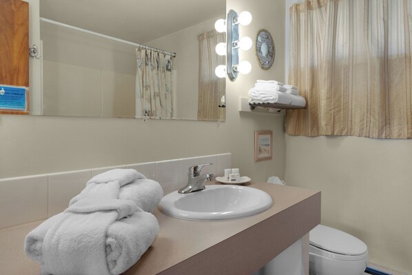 A bathroom with a sink, mirror, and a towel rack.