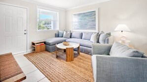 A modern living room with a grey sectional sofa, a round coffee table, and a floor lamp.