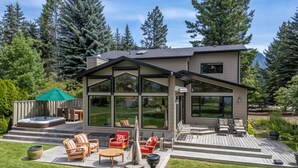 A modern house with a large deck, outdoor seating, and a hot tub. - Alpine Lake House | Beach Access | Hot Tub | Views (Windermere)